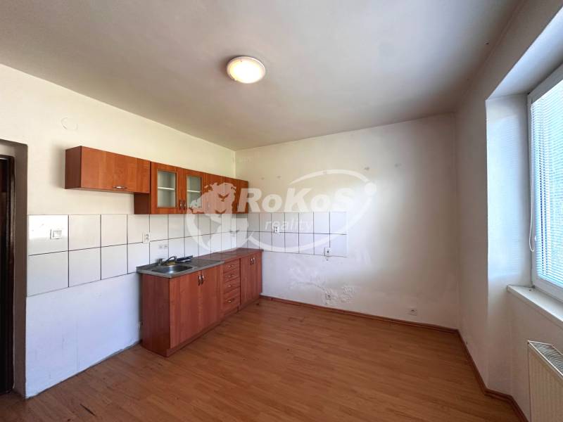Küche in einer 3-Zimmer-Wohnung mit Spüle, Fliesen und Holzboden.