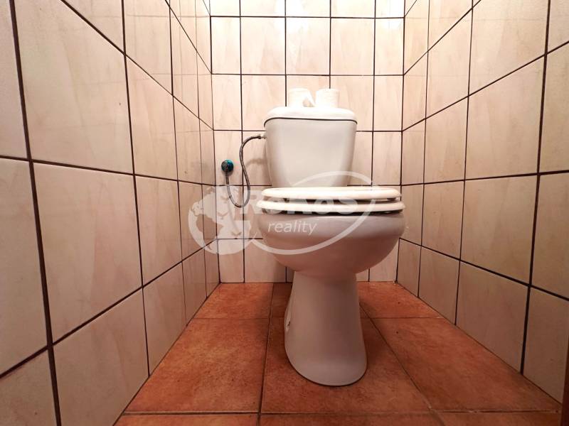 Toilette in einer 3-Zimmer-Wohnung mit Fliesen an den Wänden und auf dem Boden.