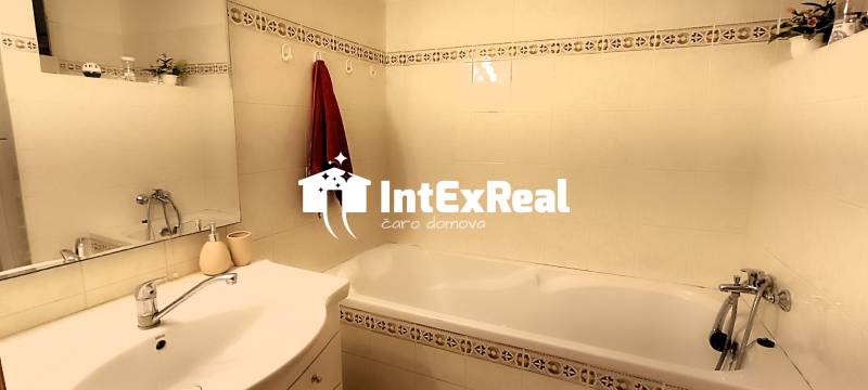 Badezimmer in einer 3-Zimmer-Wohnung mit Waschbecken, Spiegel und Badewanne.