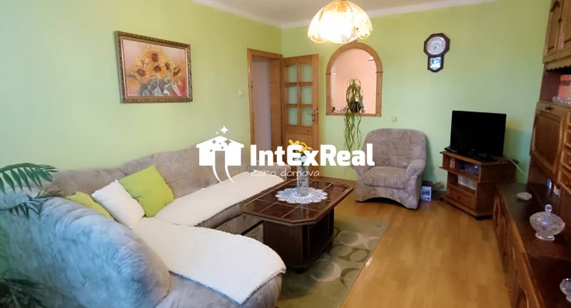 Wohnzimmer mit Sofa, Tisch und Fernseher in einer 3-Zimmer-Wohnung.