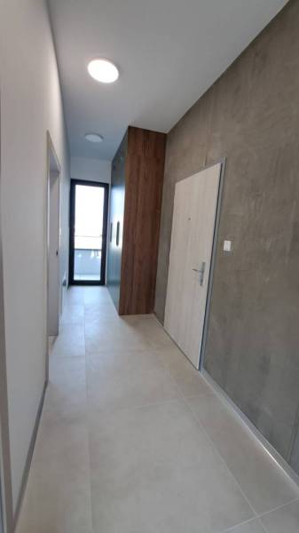 Der Flur einer 2-Zimmer-Wohnung mit Türen, hellen Wänden und einem Schrank.