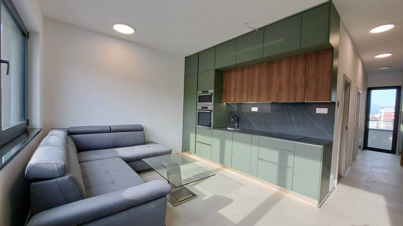 Helle Küche und Wohnzimmer mit Sofa in einer 2-Zimmer-Wohnung.