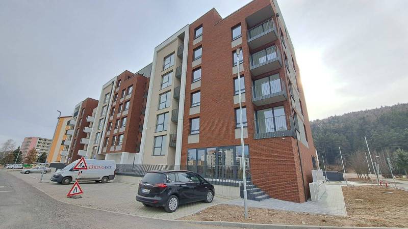 Wohngebäude in der Jilemnického-Straße in der Stadt Svit mit Parkplatz und Bauschildern.