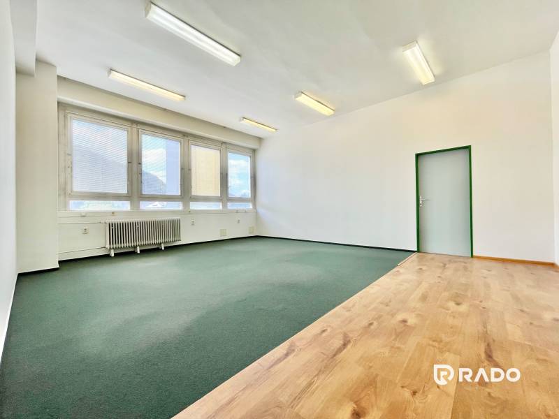 Büroinnenraum mit Fenstern, Parkett und Teppichen, geeignet für eine Arbeitsumgebung.