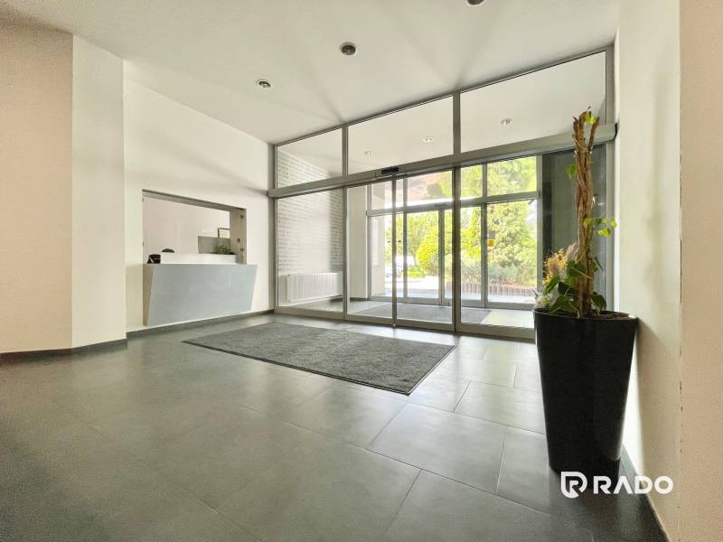 Eingangshalle mit Rezeption und großen Glastüren, Büros.