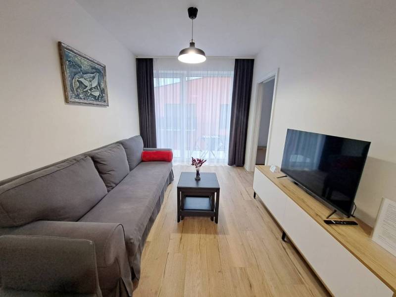 Wohnzimmer mit Sofa, Tisch und Fernseher in einer Zweizimmerwohnung.