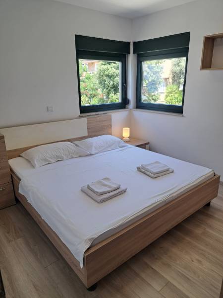 Schlafzimmer in einer 3-Zimmer-Wohnung mit Doppelbett, Fenstern und Nachttisch.