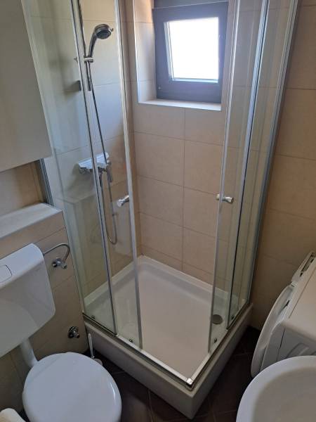 Badezimmer mit Toilette und Duschkabine in einer 3-Zimmer-Wohnung.