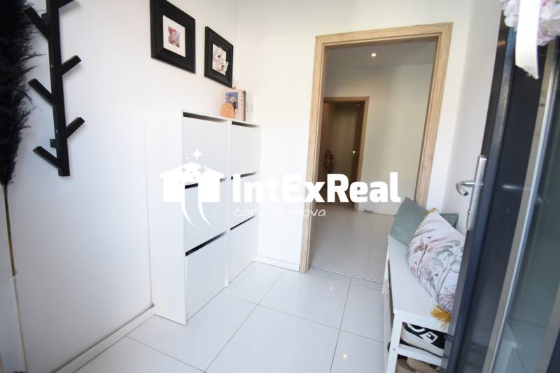 Der Flur in einem Einfamilienhaus mit Sofa, weißen Möbeln und Dekorationen.