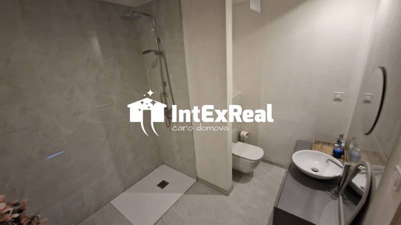 Badezimmer in einem Einfamilienhaus mit offener Dusche und Waschbecken.