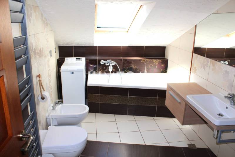 Badezimmer in einer 3-Zimmer-Wohnung mit Badewanne, Waschbecken und Waschmaschine, ideal für Komfort.