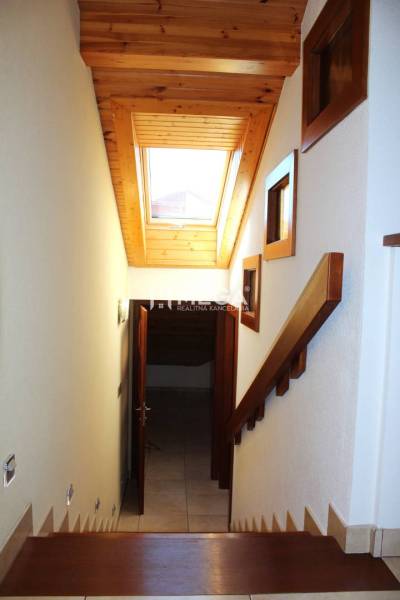 Eine Treppe mit Holzverkleidung und Dachfenster in einer 3-Zimmer-Wohnung.
