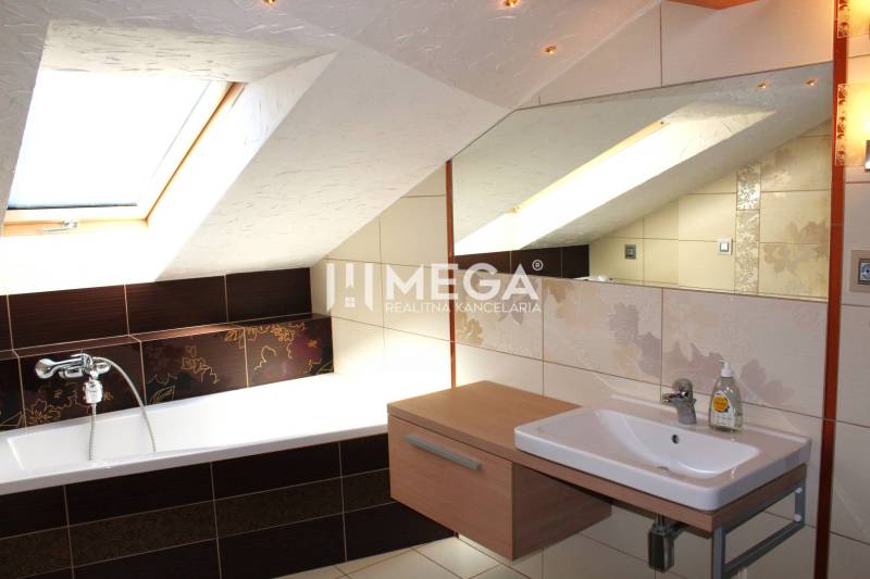 Badezimmer mit Dachfenster, Badewanne und Waschbecken in einer 3-Zimmer-Wohnung.