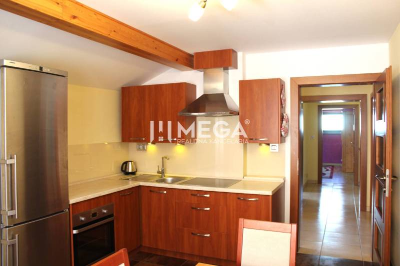 Küche mit Holzschränken und Edelstahlgeräten in einer 3-Zimmer-Wohnung.
