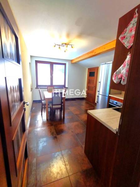 Küche in einer 3-Zimmer-Wohnung mit Tisch und Geräten.