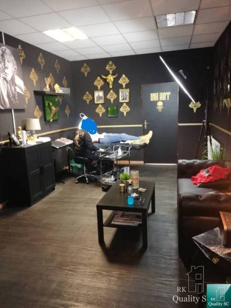 Innenraum eines Gebäudes mit einem Tattoo-Studio, goldene Dekorationen an den Wänden.
