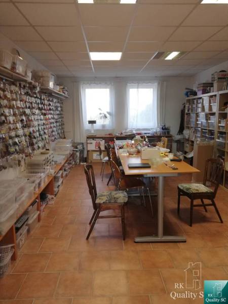 Interieur eines Gebäudes mit Tischen und Regalen voller Materialien für kreative Aktivitäten.