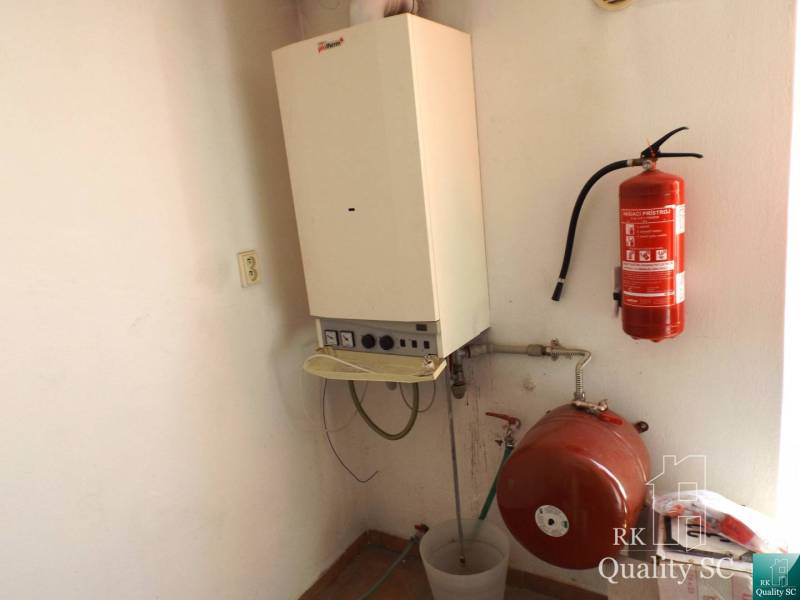 Heizung im Gebäude mit einem Kessel und einem Feuerlöscher an der Wand.
