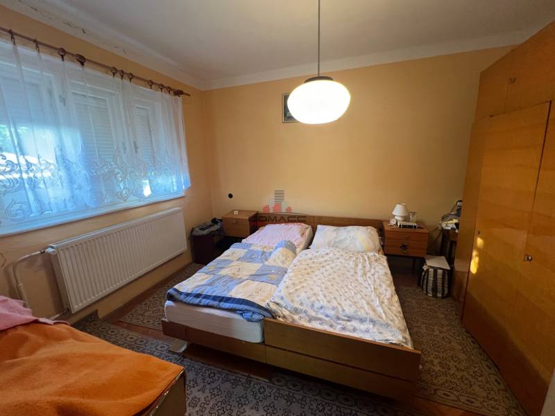 Schlafzimmer in einem Einfamilienhaus mit zwei Betten, einem Schrank und einem Teppich.