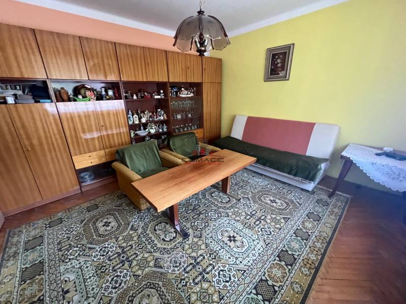 Wohnzimmer in einem Einfamilienhaus mit Möbeln, Teppich und einem Bild an der Wand.