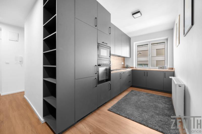 Küche in einer 3-Zimmer-Wohnung mit grauen Schränken und Holzboden.