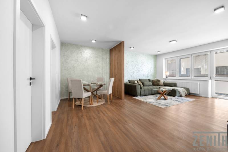 Wohnzimmer in einer 3-Zimmer-Wohnung mit Holzboden, Sofa und Esstisch.