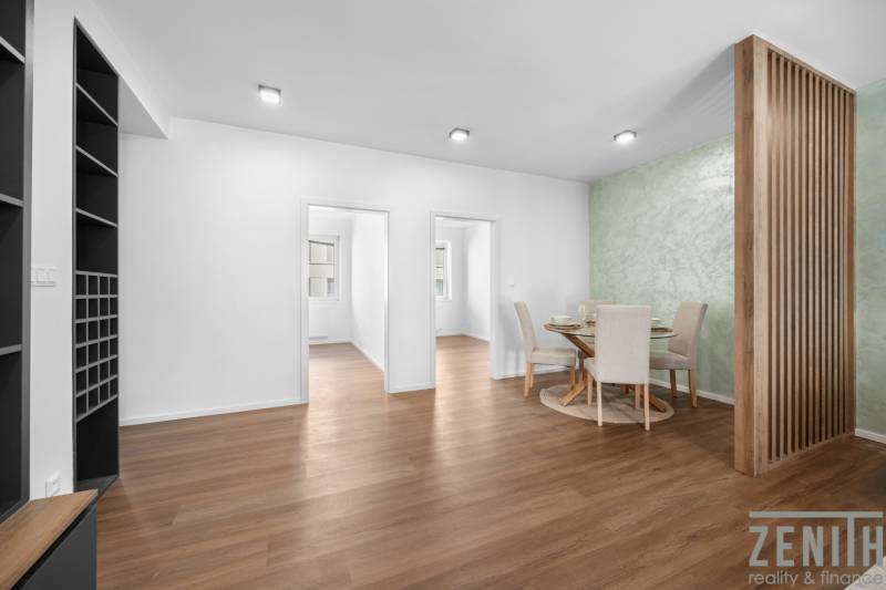 Essbereich in einer 3-Zimmer-Wohnung mit Holzboden und grüner Wand.
