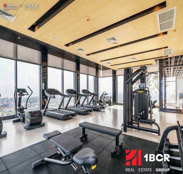 Ein Fitnessstudio mit Aussicht, ausgestattet mit Laufbändern und Kraftgeräten. Wohnungsbau.