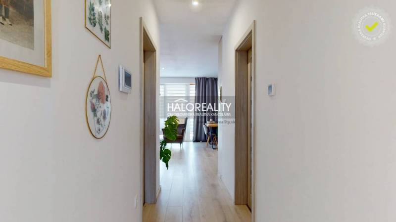Der Flur in der 3-Zimmer-Wohnung mit Holzboden und Dekorationen an den Wänden.