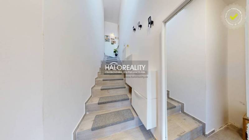 Der Flur mit Treppe in der 3-Zimmer-Wohnung hat helle Wände und dekorative Elemente.