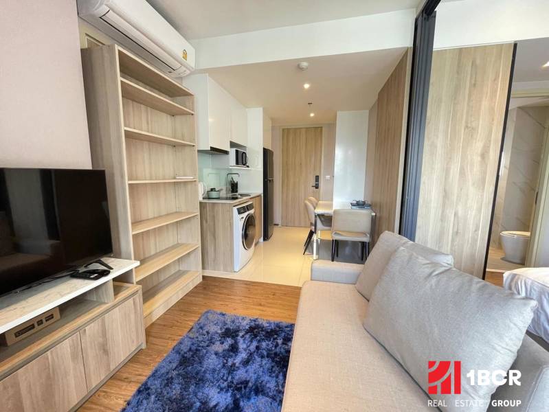 2-Zimmer-Wohnung mit Sofa, Kochnische und Esstisch, hellem Boden.