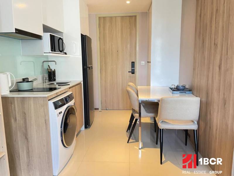 Küche in einer 2-Zimmer-Wohnung mit Esstisch und Geräten.