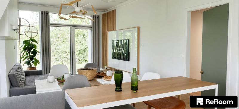 Esstisch mit Getränken, Fernseher an der Wand, Blick in den Garten, 3-Zimmer-Wohnung.