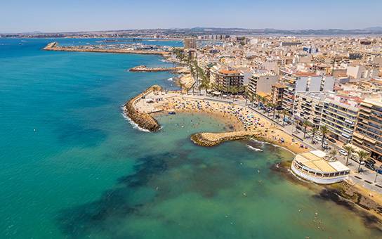 Die Küste von Torrevieja mit Blick auf den Strand und die Stadtsilhouette.