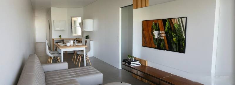 Wohnzimmer in einer 3-Zimmer-Wohnung mit Sofa, Esstisch und Fernseher.