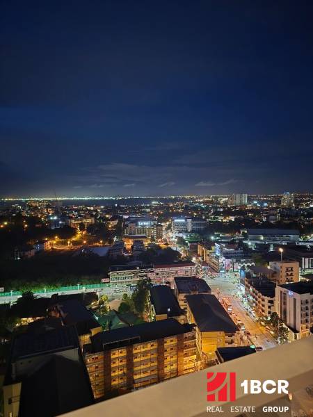 Nachtpanorama von Pattaya, Blick aus einer Einzimmerwohnung auf die beleuchtete Stadt.