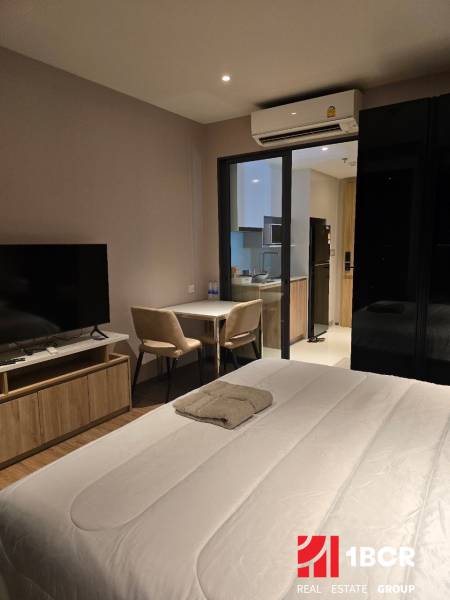 1-Zimmer-Wohnung mit TV, Bett, Tisch, Küchenzeile und Klimaanlage.