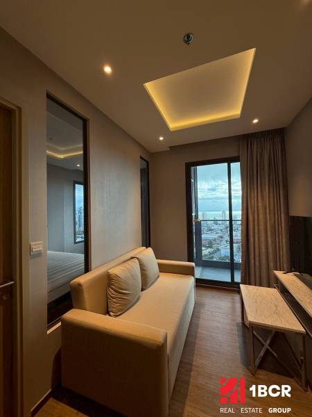 Wohnzimmer in einer 3-Zimmer-Wohnung mit Sofa, Fernseher und Blick auf die Stadt.