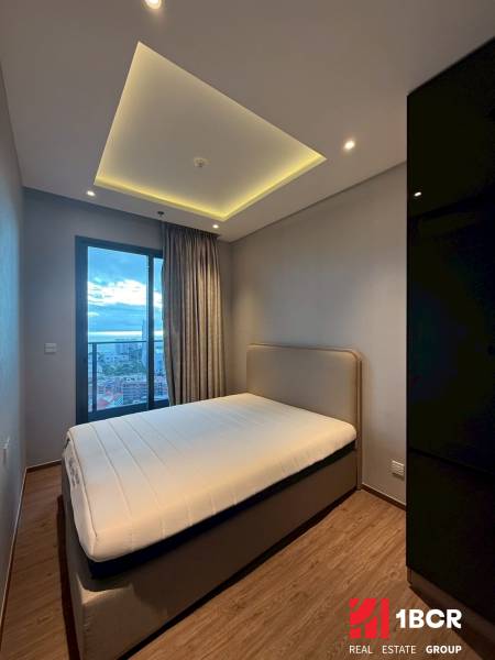 Schlafzimmer in einer 3-Zimmer-Wohnung mit Bett, Einbauschrank und Vorhängen am Fenster.