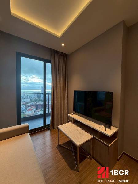 Obývačka in einer 3-Zimmer-Wohnung mit Sofa, TV-Schrank und Stadtblick.