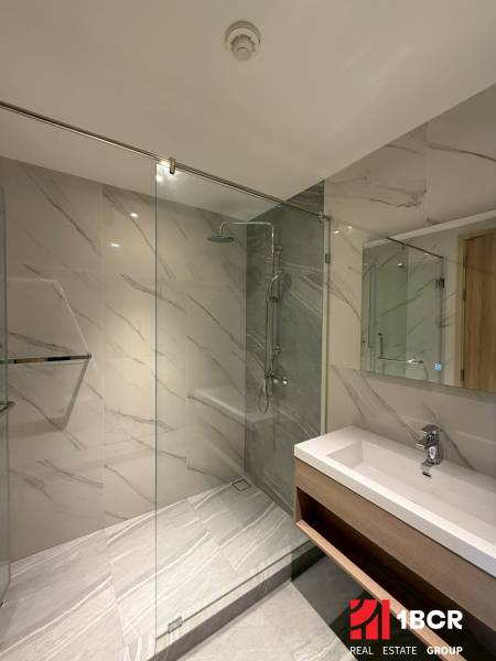 Badezimmer mit Duschkabine und Waschbecken in einer 3-Zimmer-Wohnung mit elegantem Design.