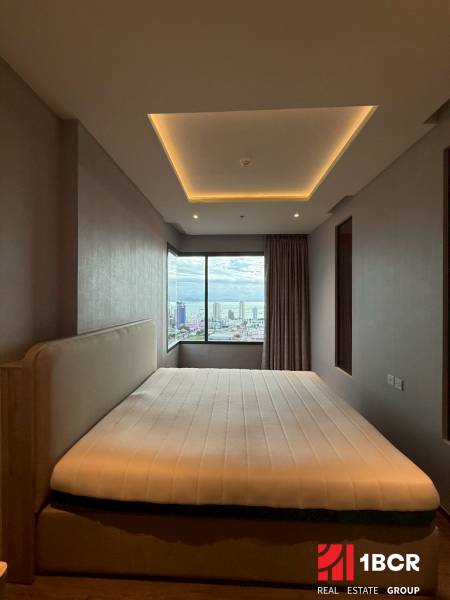 Schlafzimmer in einer 3-Zimmer-Wohnung mit großem Fenster und Blick auf die Stadt.
