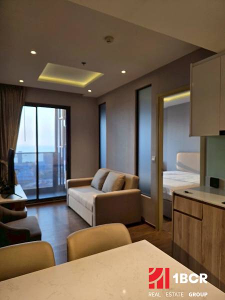Wohnzimmer in einer 3-Zimmer-Wohnung mit Sofa, Aussicht und Küchentheke.
