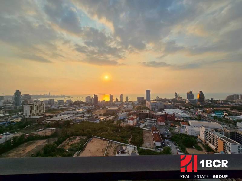 Blick von einer 3-Zimmer-Wohnung in Pattaya auf den Sonnenuntergang über der Stadt und dem Meer.