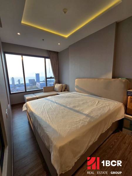 3-Zimmer-Wohnung mit Bett und Blick auf die Stadt und das Meer.