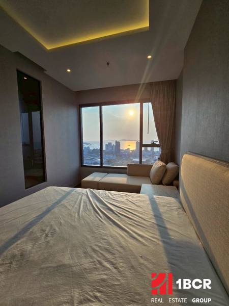 Ein Schlafzimmer in einer 3-Zimmer-Wohnung mit Blick auf den Sonnenuntergang über der Stadt.