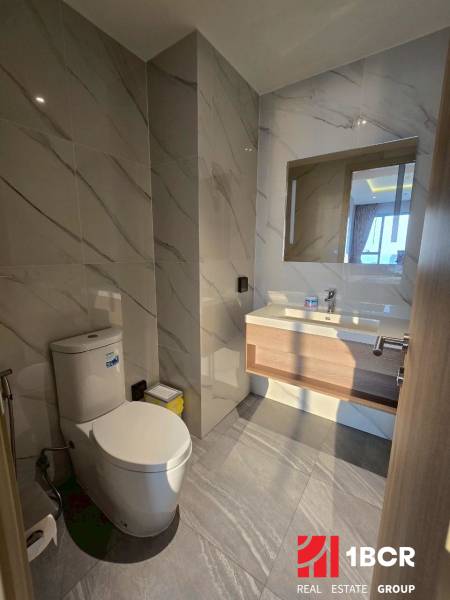 Badezimmer mit Marmorfliesen und Toilette in einer 3-Zimmer-Wohnung.