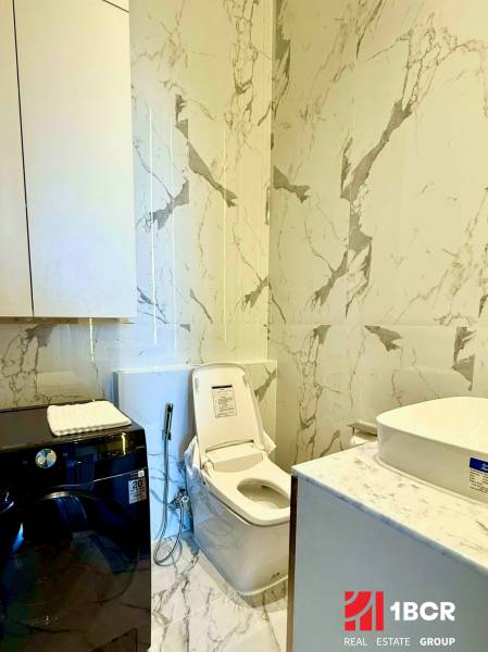 Badezimmer in einer 4-Zimmer-Wohnung mit Toilette, Waschmaschine und Marmorsternen.