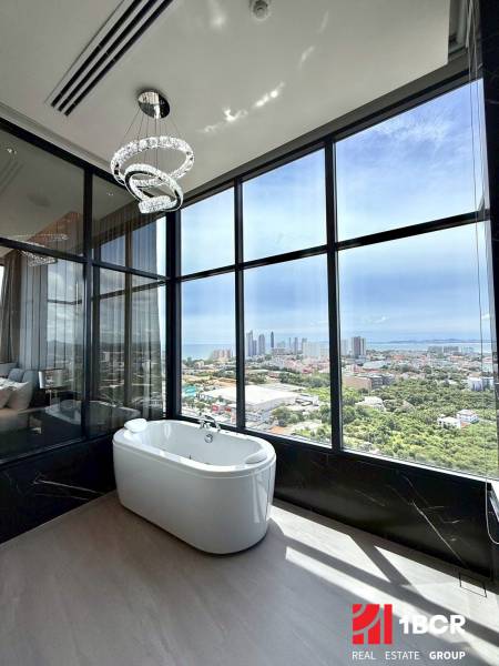 Blick aus einer 4-Zimmer-Wohnung auf die Stadt Pattaya mit einer Badewanne und einem Panoramafenster.