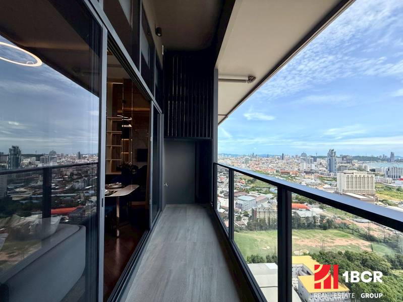 Blick aus einer 4-Zimmer-Wohnung in Pattaya. Balkon mit verglastem Geländer und Stadtpanorama.